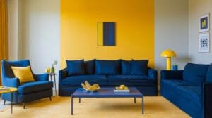 A sunny yellow accent wall complemented by deep navy blue furniture, showcasing vibrant Airbnb design trends for a stylish and inviting atmosphere.