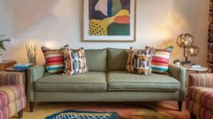 Playful green couch adorned with bold patterned throw pillows, embodying trendy Airbnb design trends for a vibrant living space.